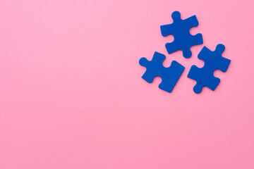 Blue puzzle pieces on paper background top view