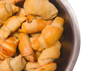 Croissants. Fresh homemade cakes in a heap in a metal dish on a white isolated background. Buns
