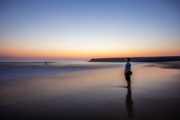silhouette of person on the beach at sunset