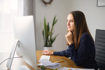 Side view at the female employee working with a trendy PC in modern office. Smart and confident...