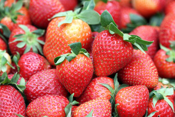 Fresh strawberries with leaves on a market. Ripe strawberry for background
