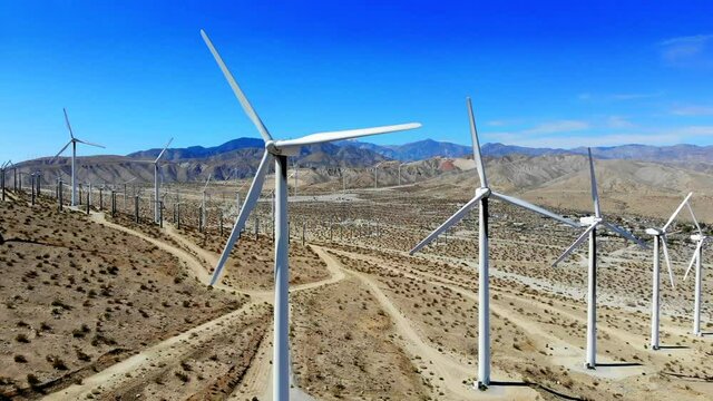 Windmills, wind turbines aerial 4k drone slow pull back on hills in desert, energy, green, renewable, huge power generating farm,  with Mt San Gorgonio in BG, in Palm Springs, Coachella, Cabazon, CA