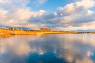 Sunset on the lake. Dramatic Spring Clouds over the still Lake.
