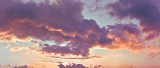 Colorful clouds in the sky highlighted by the rays of the setting sun.
