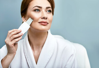 Ultrasonic facial peeling for a woman's face with ultrasonic scrubber. Cleansing facial skin