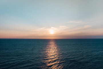 a sunset over the blue sea