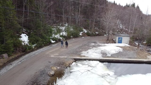 Deux femmes marchent sur un chemin forestier pr&egrave;s d'un bassin d'eau au printemps
