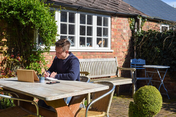 Man working from home remote working online in the garden