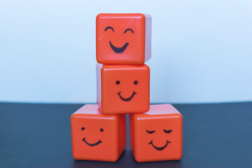 Positive emotions concept, funny faces drawn on cubes.
