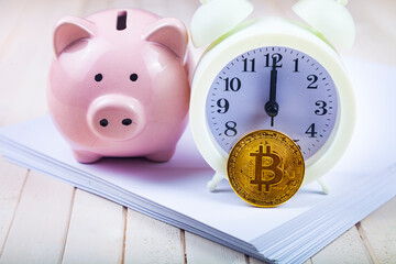 Pig piggy bank and bitcoin, clock and stack of papers on the background.