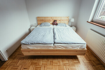 Stone pine bed: Empty wooden bed with pillow and blanket