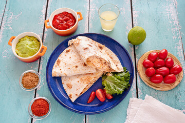 Close-up of Mexican quesadillas, with guacamole, tomatoes and spices