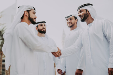 Group of businessmen talking on the street in Dubai