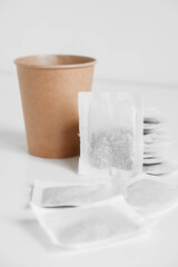 Paper cup and bags with tea on a white background. Copy, empty space for text