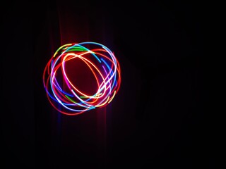 Closeup of Neon Multicolored Spirograph geometric abstract pattern isolated on a Black background with copy space. Made using Long exposure technique.Geometry. Pendulum pattern. © sanju's view