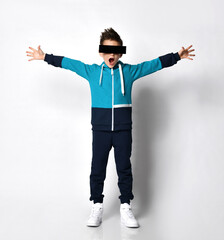 Excited young guy in a comfortable tracksuit hoodie, wearing augmented reality glasses, dark glasses of unusual shape.