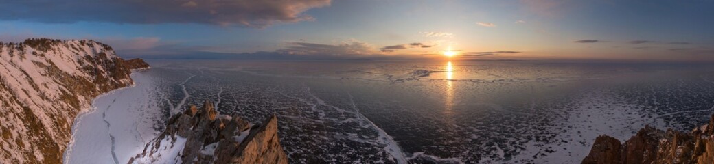 Big panoramic aerial view of winter landscape in Siberia with frozen lake Baikal and beautifil sunrise