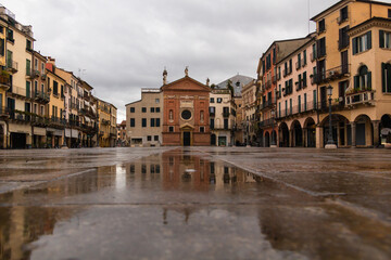 ciudad antigua en dia lluvioso, reflejos en charcos de agua