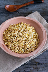 Uncooked wheat grains grown in france on rustic background