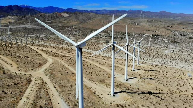 Nice sweep R to L to line up shot of spinning blades of windmills, wind turbines energy, green, renewable, power generating farm, aerial 4k drone, Palm Springs, Coachella Valley, Cabazon, California