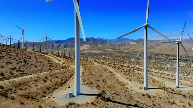 Windmills, wind turbines- aerial 4k drone boom up and ascend, energy, green, renewable, huge power generating farm on desert hills, Mt San Gorgonio in BG in Palm Springs, Coachella Valley, Cabazon, CA