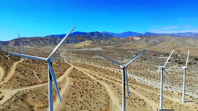 Windmills, wind turbines energy, green, renewable, huge power generating farm on desert hills, aerial 4k drone big sweep around R to L and close up, in Palm Springs, Coachella Valley, Cabazon, Calif