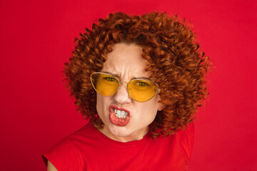 Caucasian woman's portrait isolated over red studio background with copyspace