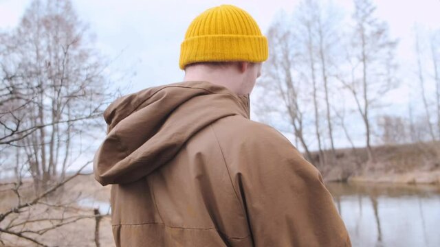 Backshot of a young traveller with yellow backpack walking in the forest. High quality 4k footage