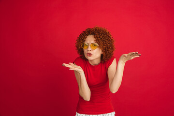 Caucasian woman's portrait isolated over red studio background with copyspace