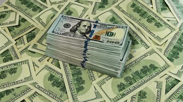 US dollars bundle closeup rotation on the top of usd banknotes heap. Cash money background, able to loop