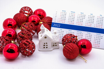 2022 calendar and Christmas tree balls. Souvenir house and 2022 calendar. Red Christmas balls and...