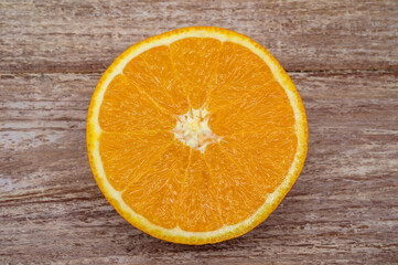 Orange on a wooden background. Half an orange on a wooden table. Banner with orange.