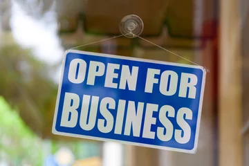 Deurstickers Close-up on a blue sign in the window of a shop displaying the message "Open for business". © BreizhAtao