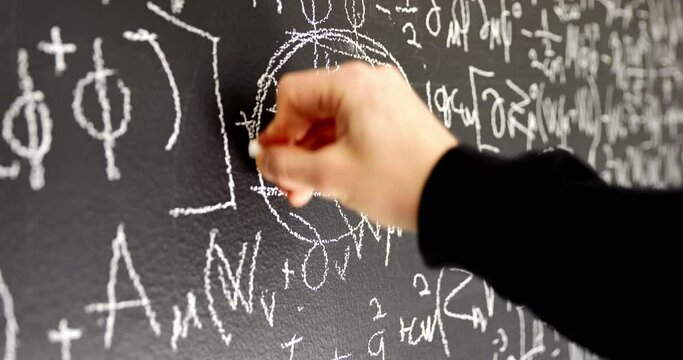 Writing mathematical formulas on dark black chalk board