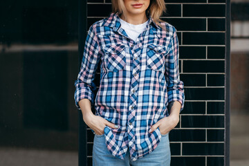 Fashion portrait of beautiful woman with beautiful face, wearing grunge plaid shirt. Posing alone.