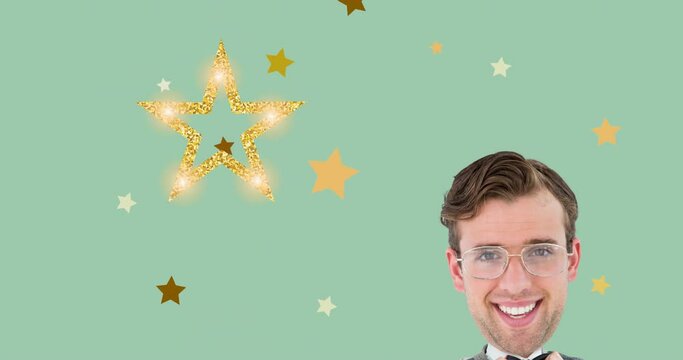 Animation of smiling man holding his bow tie moving over christmas decoration stars on green