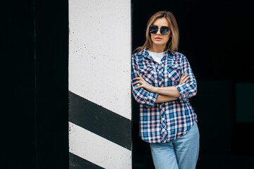 Fashion portrait of beautiful woman with beautiful face, wearing grunge plaid shirt. Posing alone.