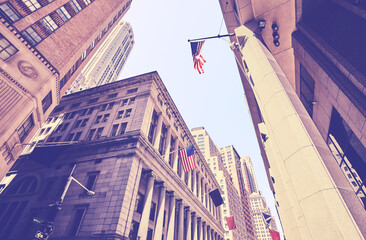 Looking up at Manhattan buildings at the Wall Street, color toning applied, New York City, USA.