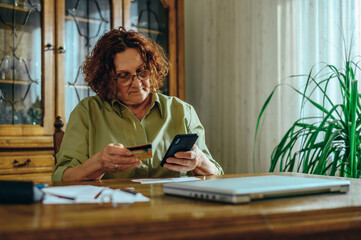 Senior woman using a smartphone at home