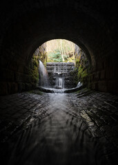 Creepy dark eerie old sewer brick tunnel spooky shadows water river running through flowing light...