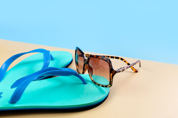 Beach slippers, flip-flops, sunglasses and a camera on the seashore. Summer vacation concept....