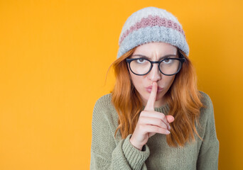 Psst. Young woman holding finger on lips, keep the secret concept, isolated on white background