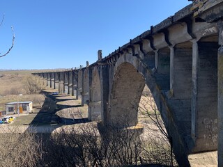An old abandoned railway viaduct that used to go by train. Old arched bridge in spring

