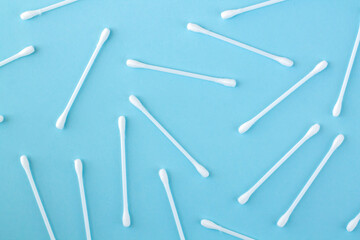 Pattern of white plastic cotton swabs or sticks top view on blue background