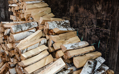 Birch logs in the form of firewood in a pile in the yard.