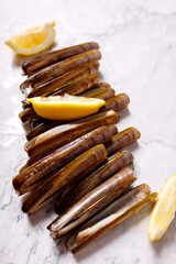 Fresh Razor Clams (Cannolicchi) on a  marble background. Rare clams of Mediterranean cuisine, fish market