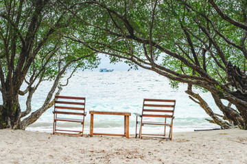 Fototapeta na wymiar bench on the beach and ship with tree frame at Freedom beach, Koh Tao, Thailand