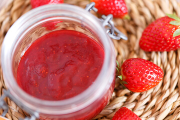 Strawberry jam in a jar on wooden background