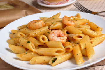 Delizioso piatto di pennette con crema di salmone affumicato e gamberetti sgusciati.