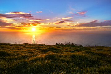 Naklejka na ściany i meble sunset over the sea from the cliff